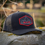A black NCB patch style snapback hat positioned on a rock