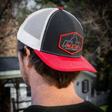 A Red/Black/White NCB snapback hat worn backwards on a model's head